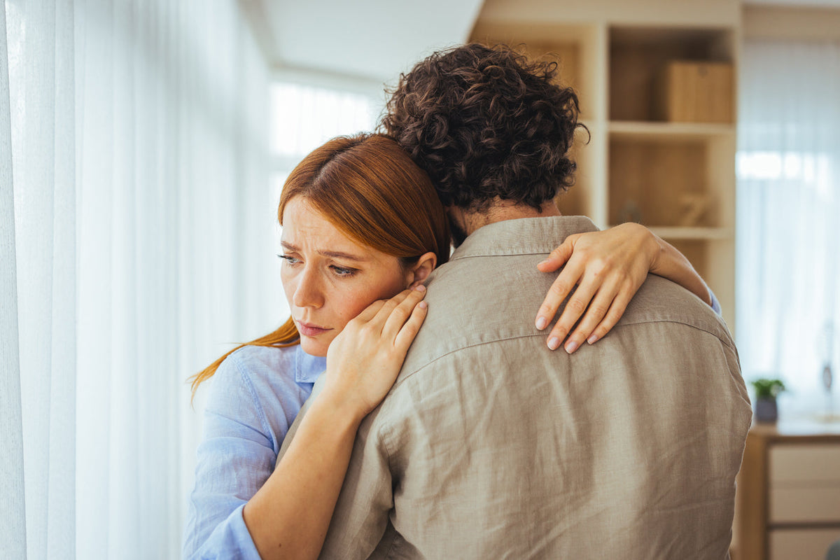 a woman hugs a man who has read the partner's guide to perimenopause