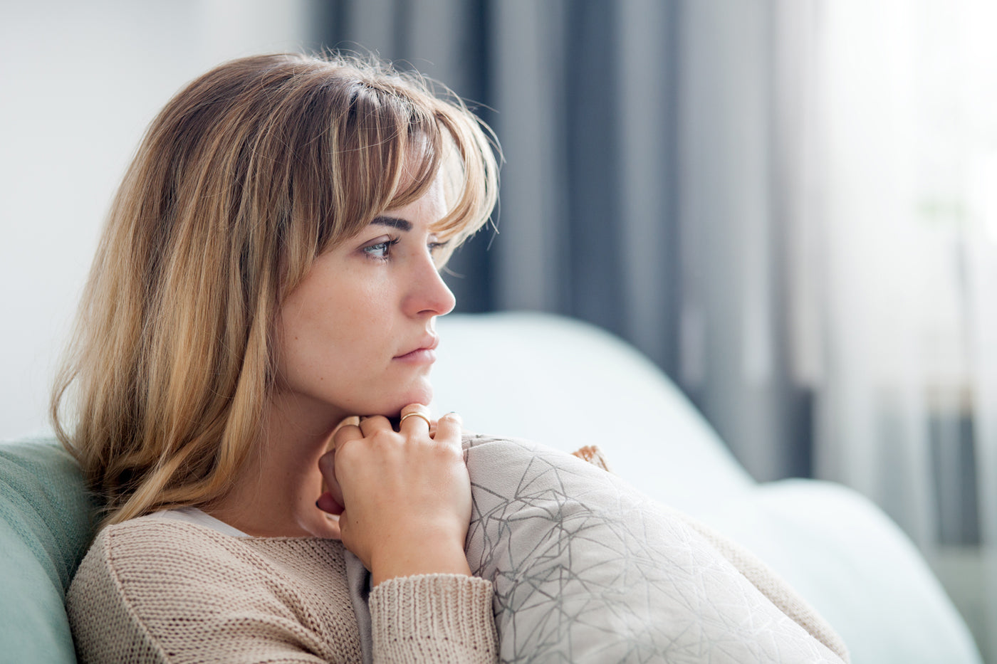 Woman potentially experiencing PCOS / PMOS symptoms looking melancholy