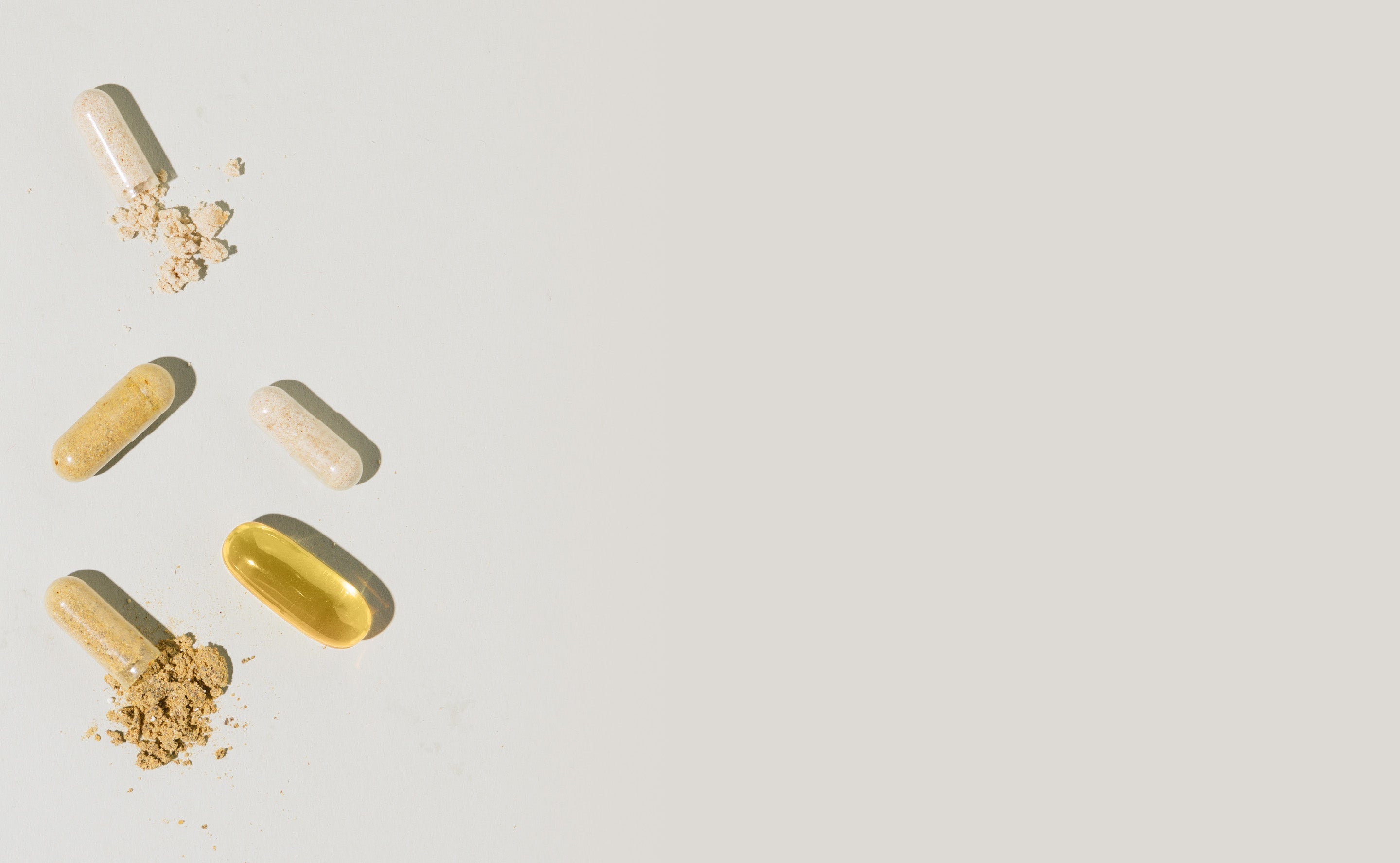 BrainMD Brain & Body Power: image of 2 solid capsules, 2 open capsules revealing powder and a softgel on a white surface