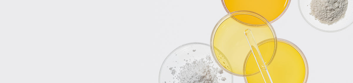 Oils and powders in circular containers against a white background.