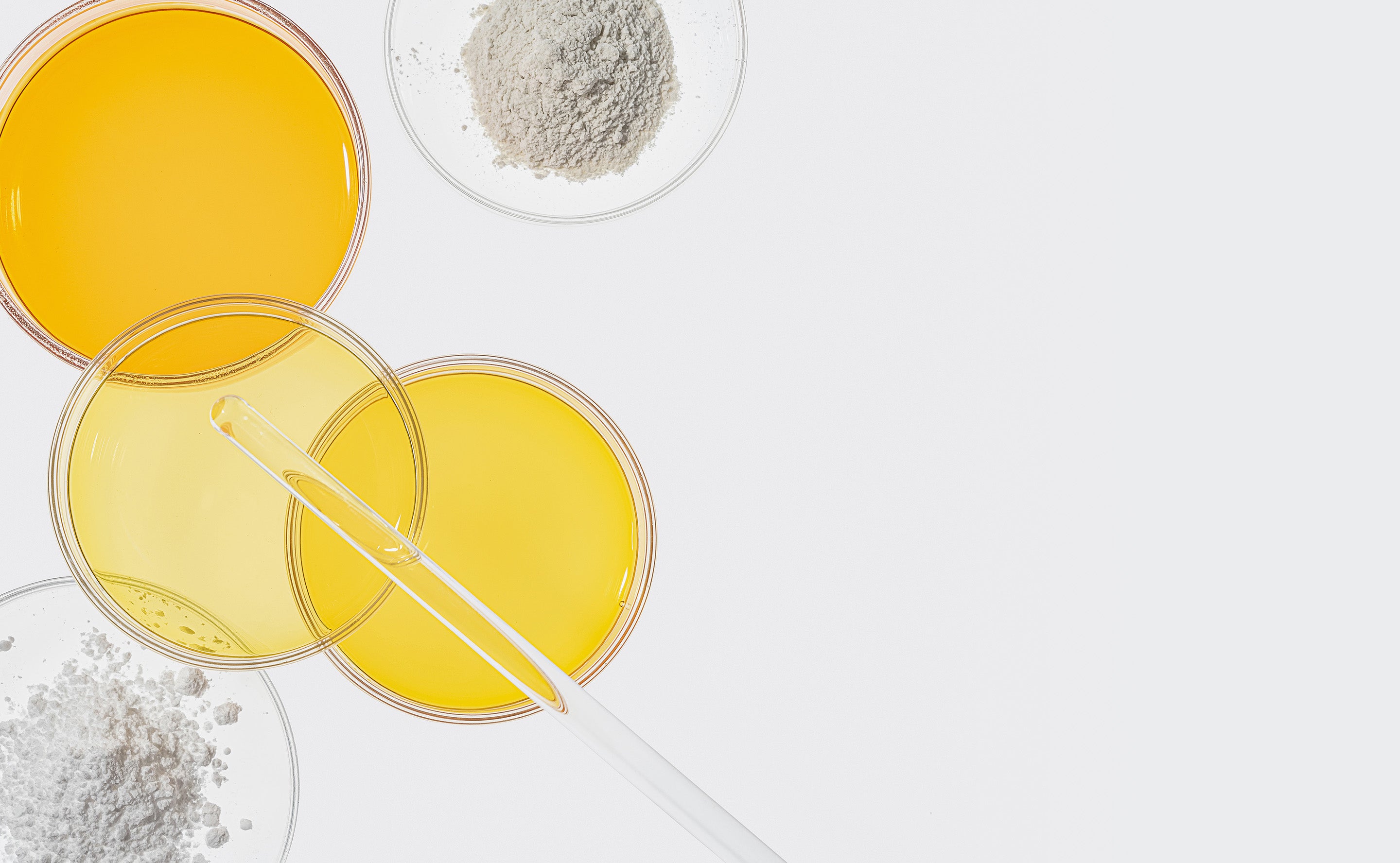 BrainMD Total Immune Health Bundle: glass slides containing white powder and yellow oil against a white background