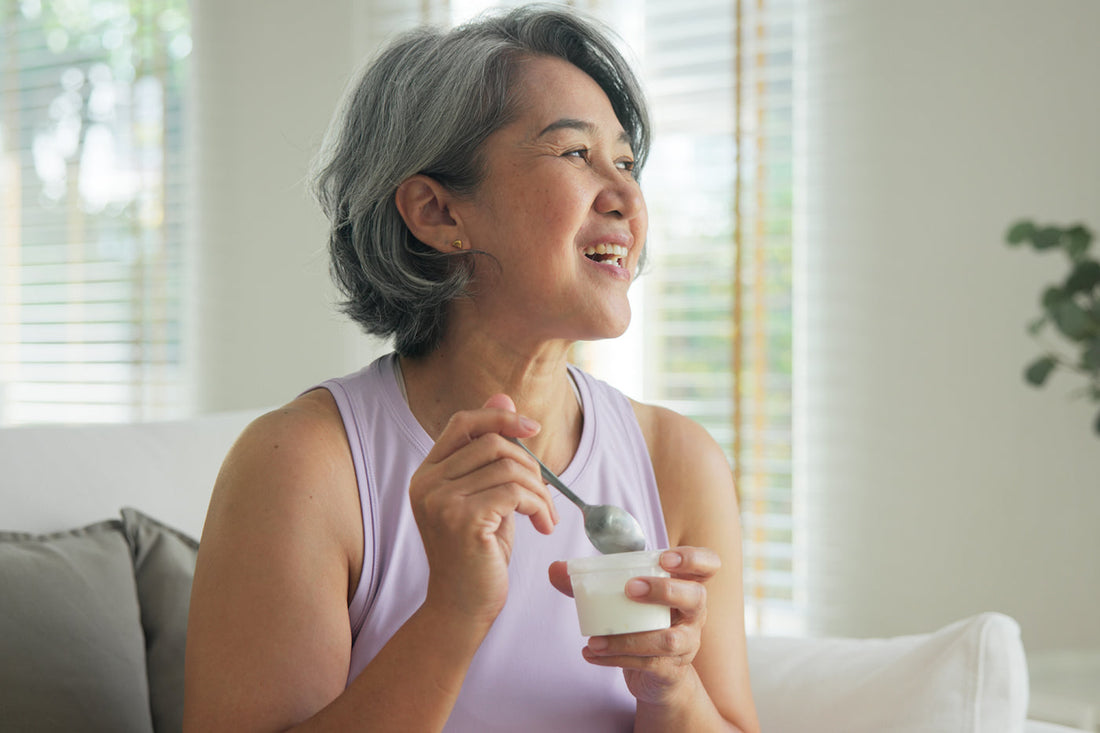 a woman eating yogurt that may contain psychobiotics