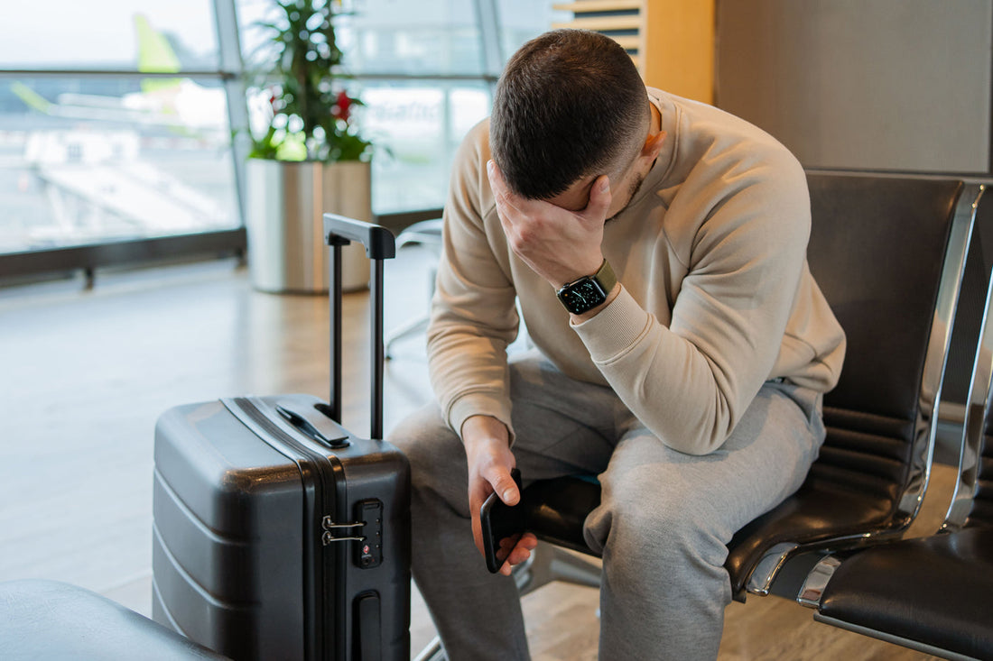 man with head in hands suffering from jet lag