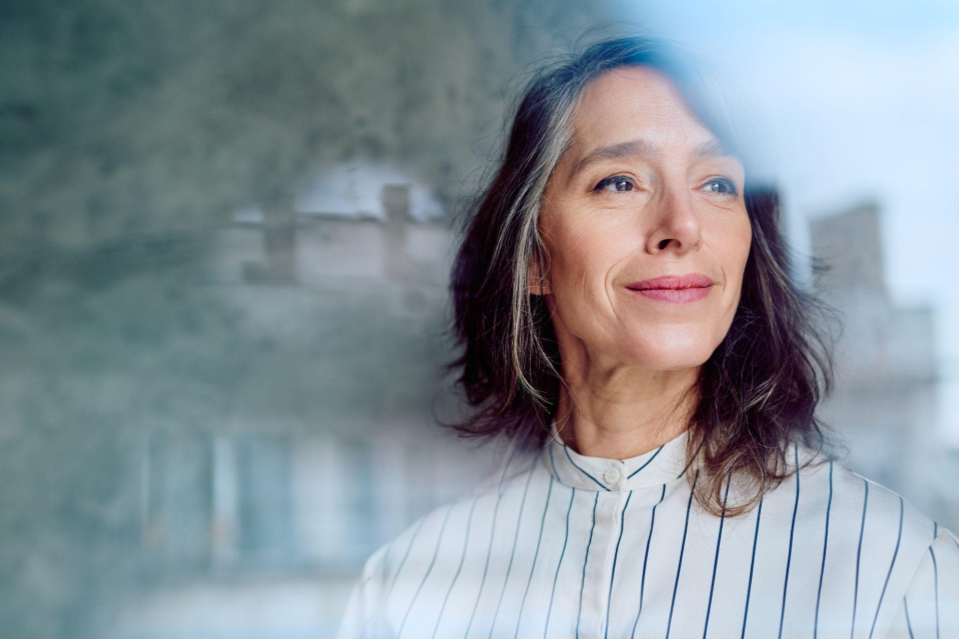 woman staring out a window contemplating what happens in your brain when you pray or meditate