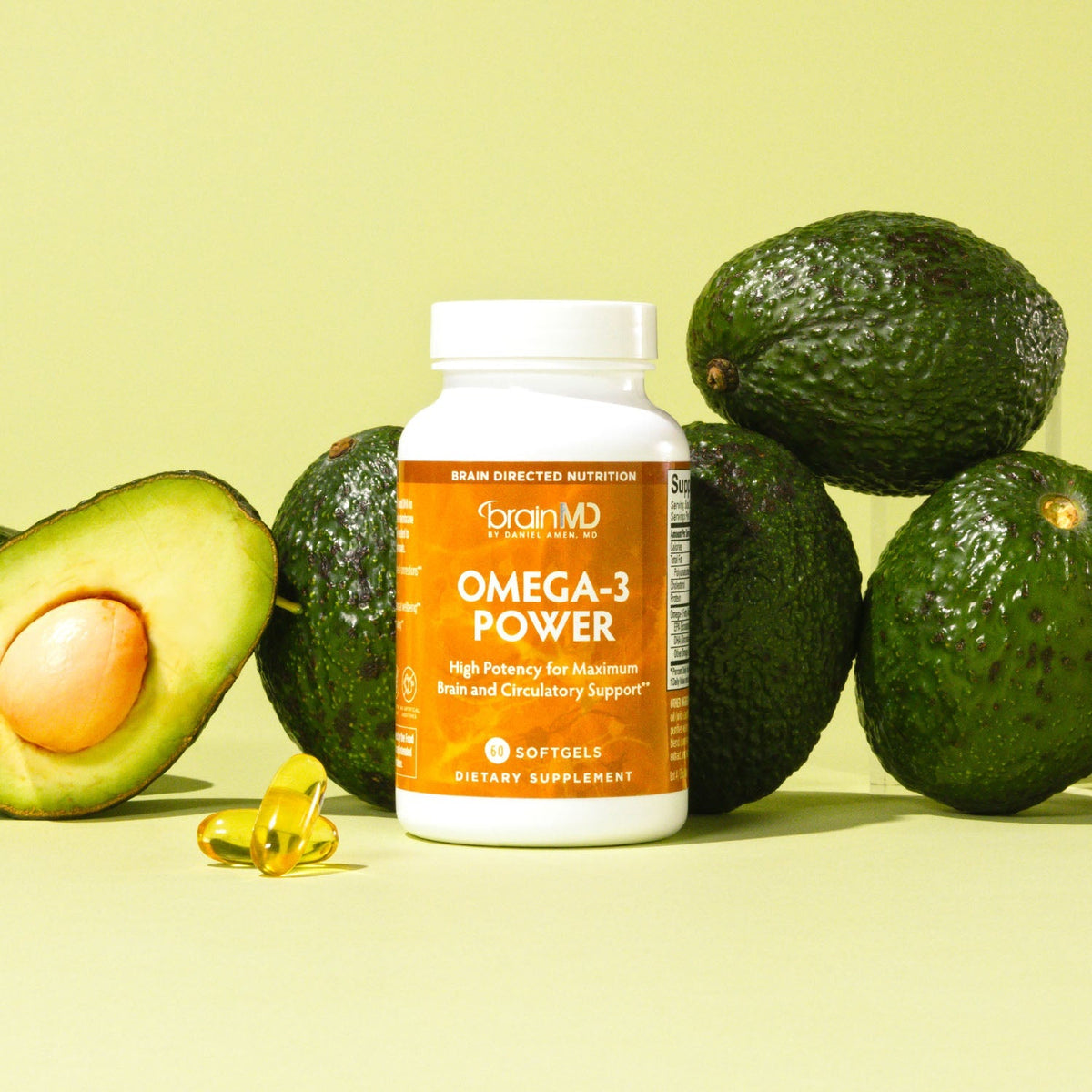BrainMD Omega-3 Power bottle and softgels with avocados on a light green background
