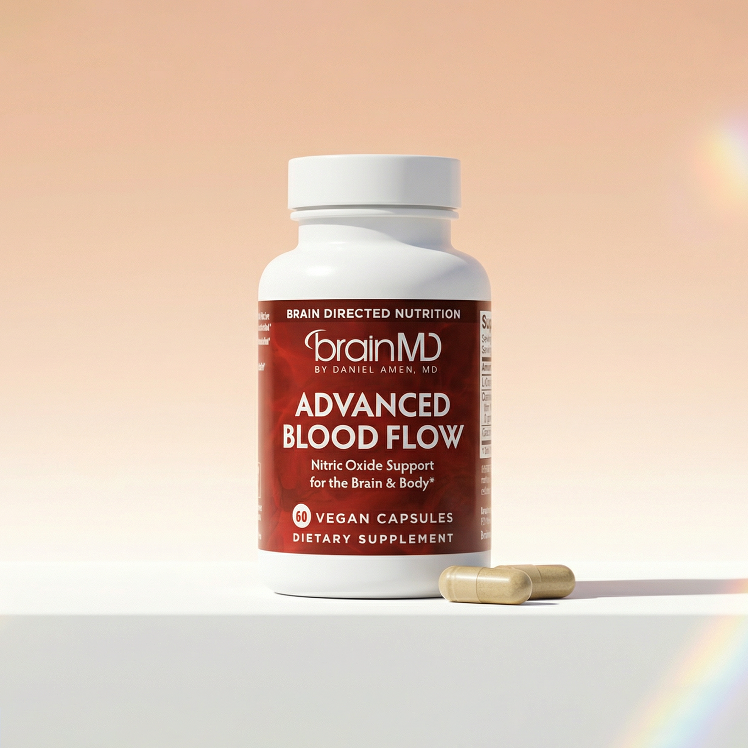 Red supplement bottle with capsules at the base against a peach-colored background.