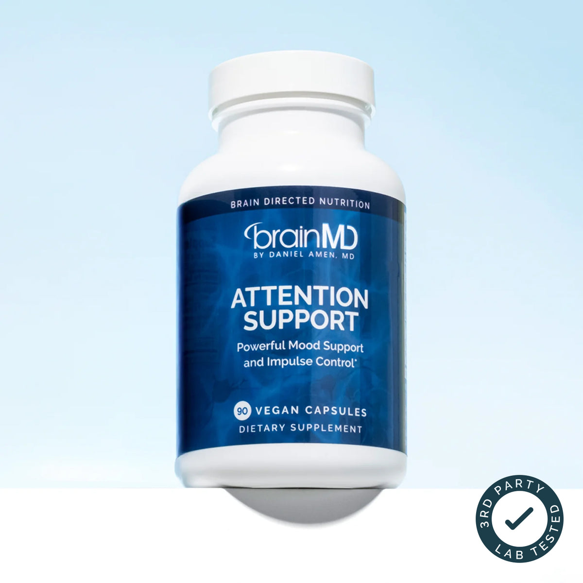 BrainMD Attention Support bottle of vegan capsules on a blue sky background with a third-party tested badge