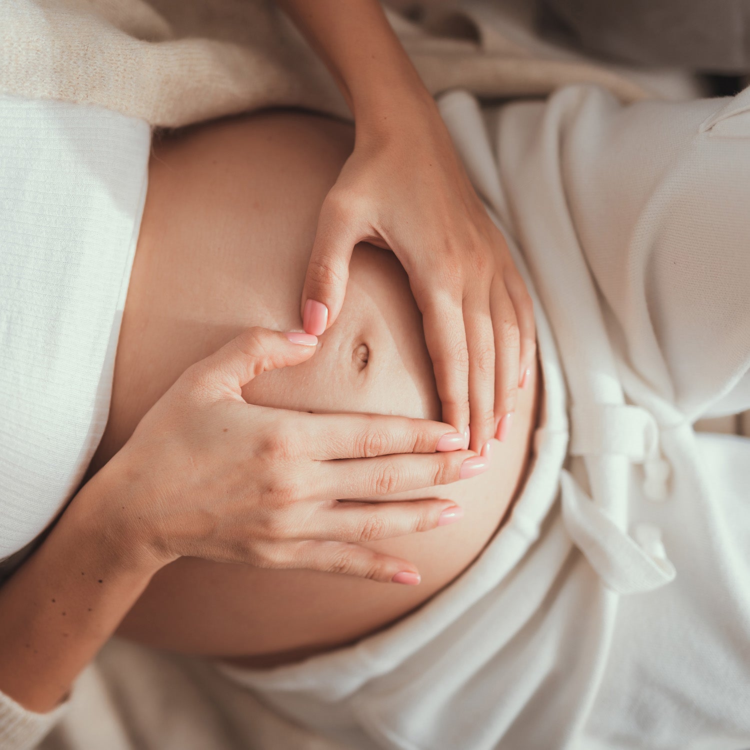 BrainMD Bundle Of Joy: woman making a heart shape with her hands on her pregnant belly