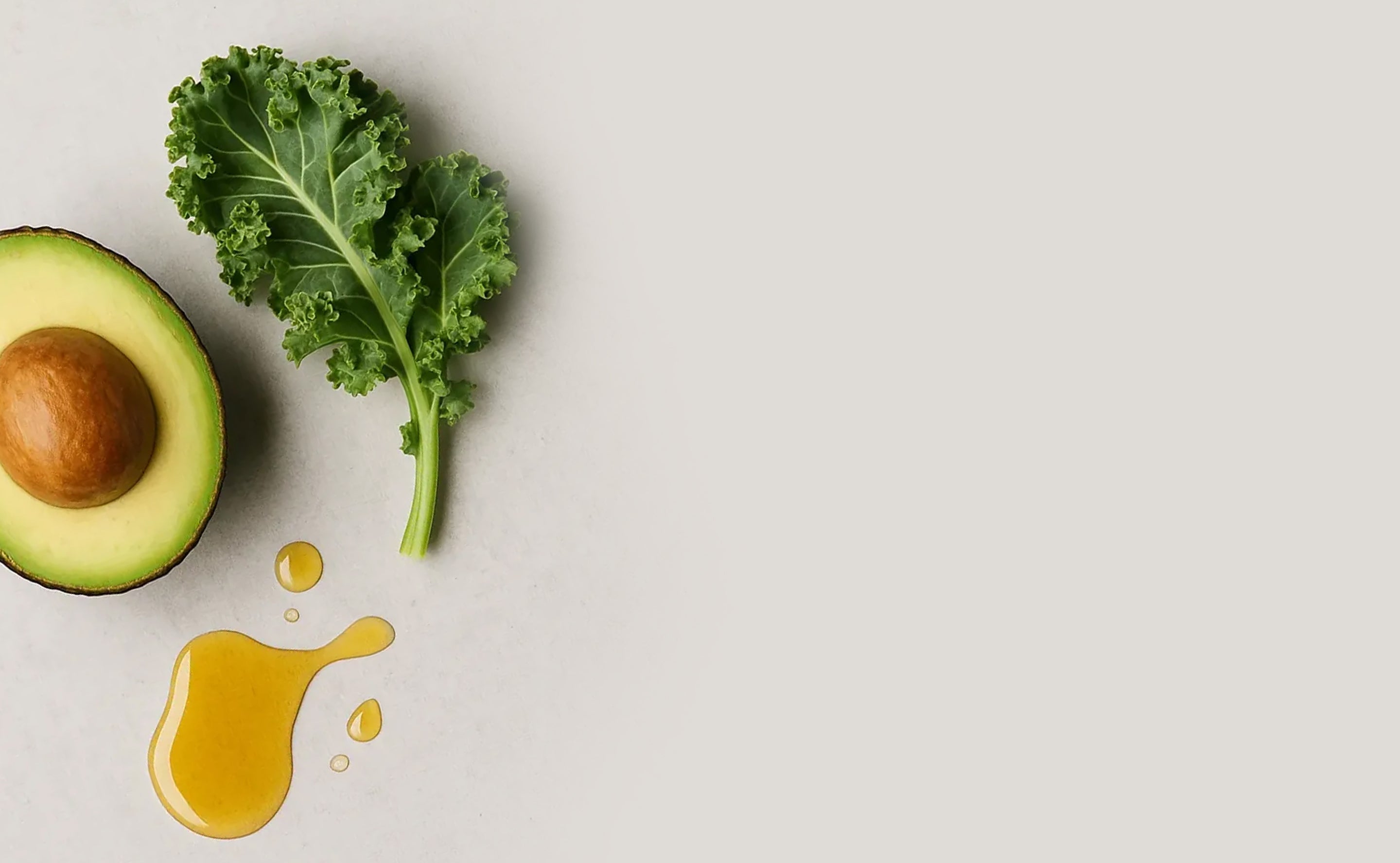 BrainMD Bundle Of Joy: image of leafy green, half avocado and fish oil on an off-white surface