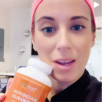 Dr. Jess BrainMD influencer holding a BrainMD Magnesium Chewables supplement bottle.