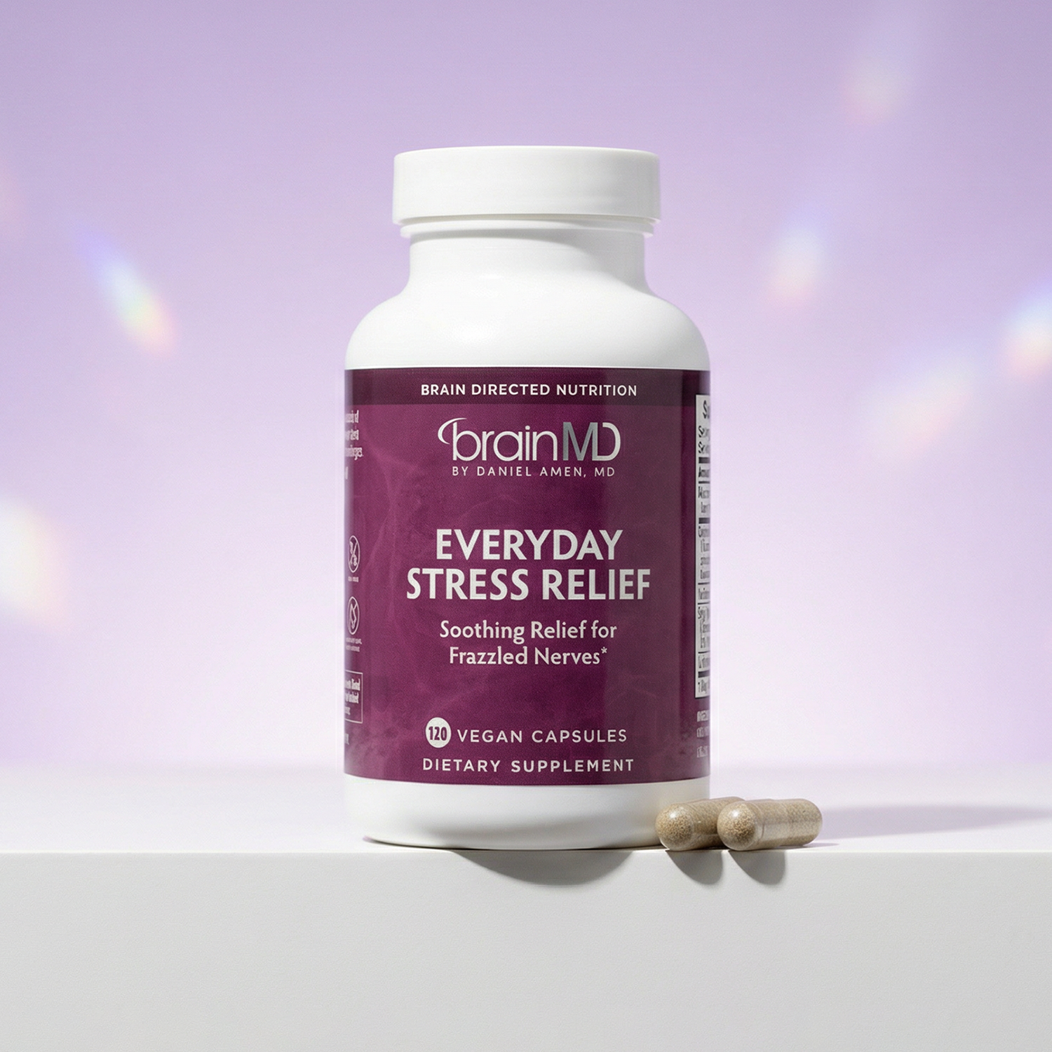 Purple supplement bottle with capsules at the base against a lavender background.