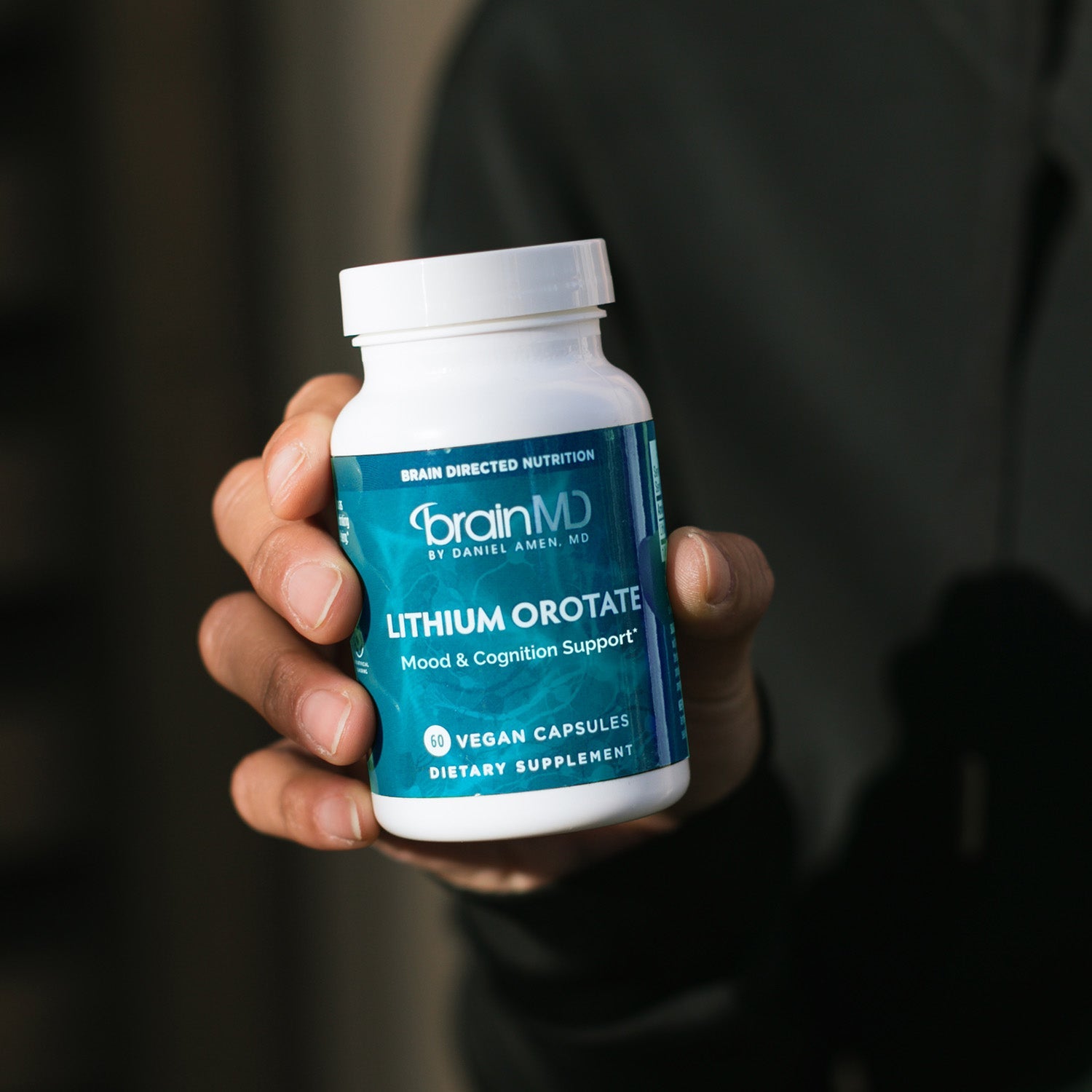 BrainMD Lithium Orotate: person with dark shirt holding bottle of Lithium Orotate
