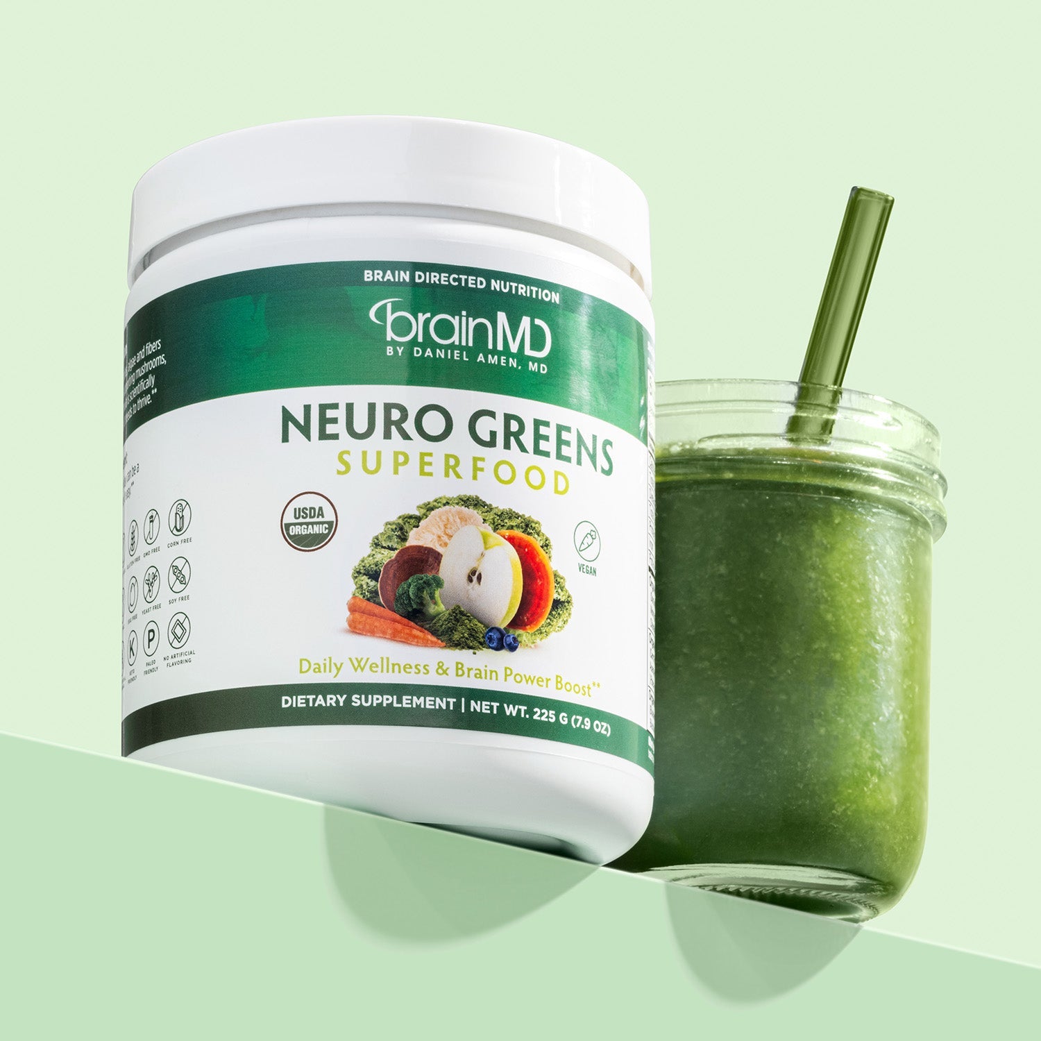 BrainMD Neuro Greens Superfood: green & white supplement bottle with green smoothie in a jar against a light green background