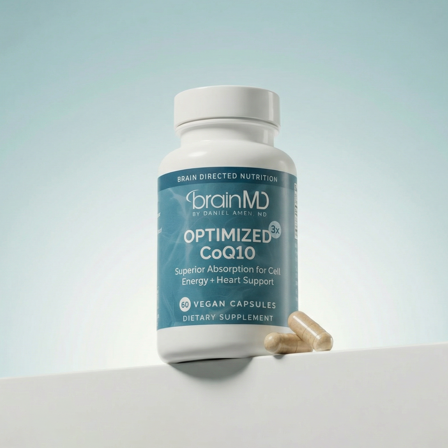 Blue supplement bottle with capsules at the base against a powder blue background.