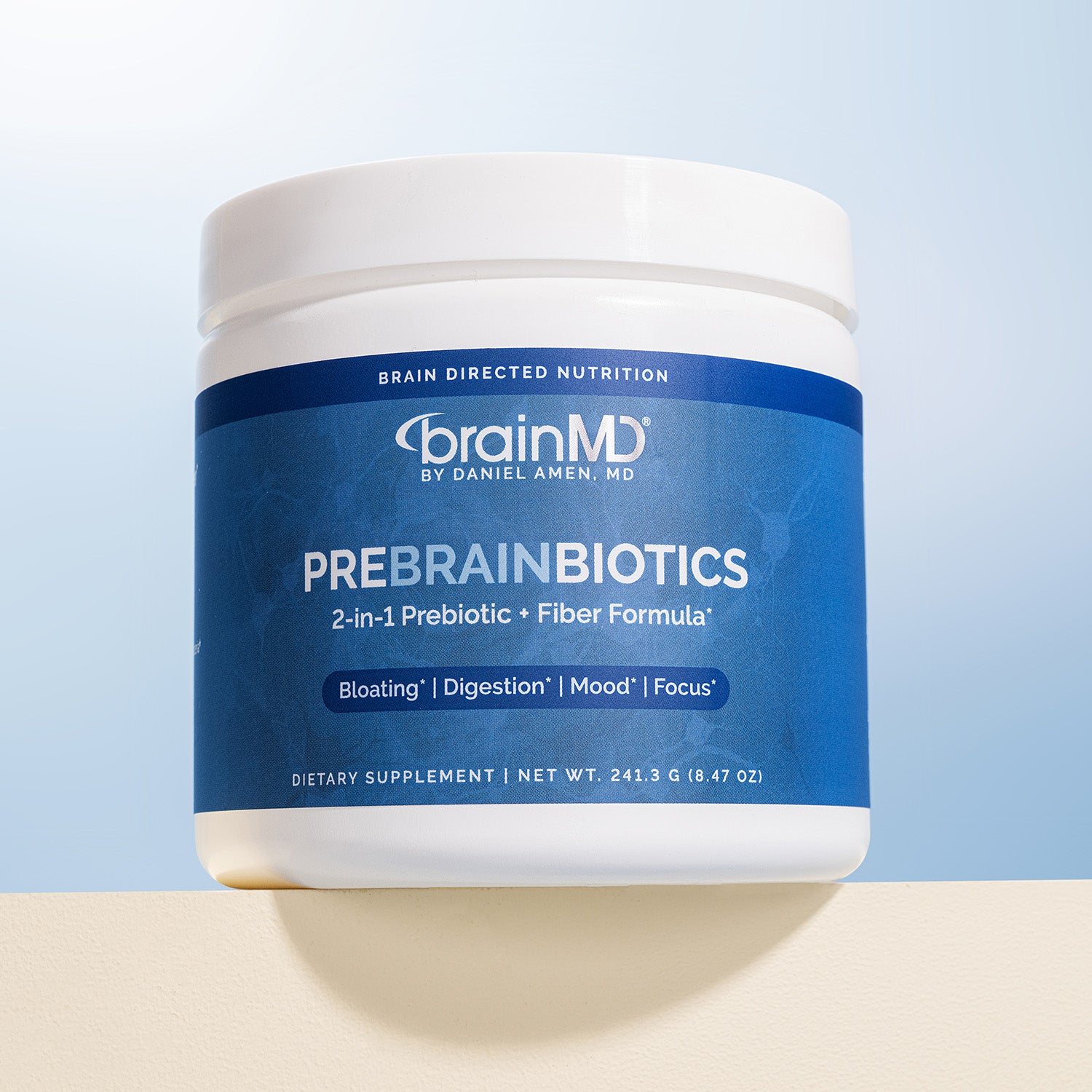 Blue tub of prebiotic powder against a cloudy sky background.