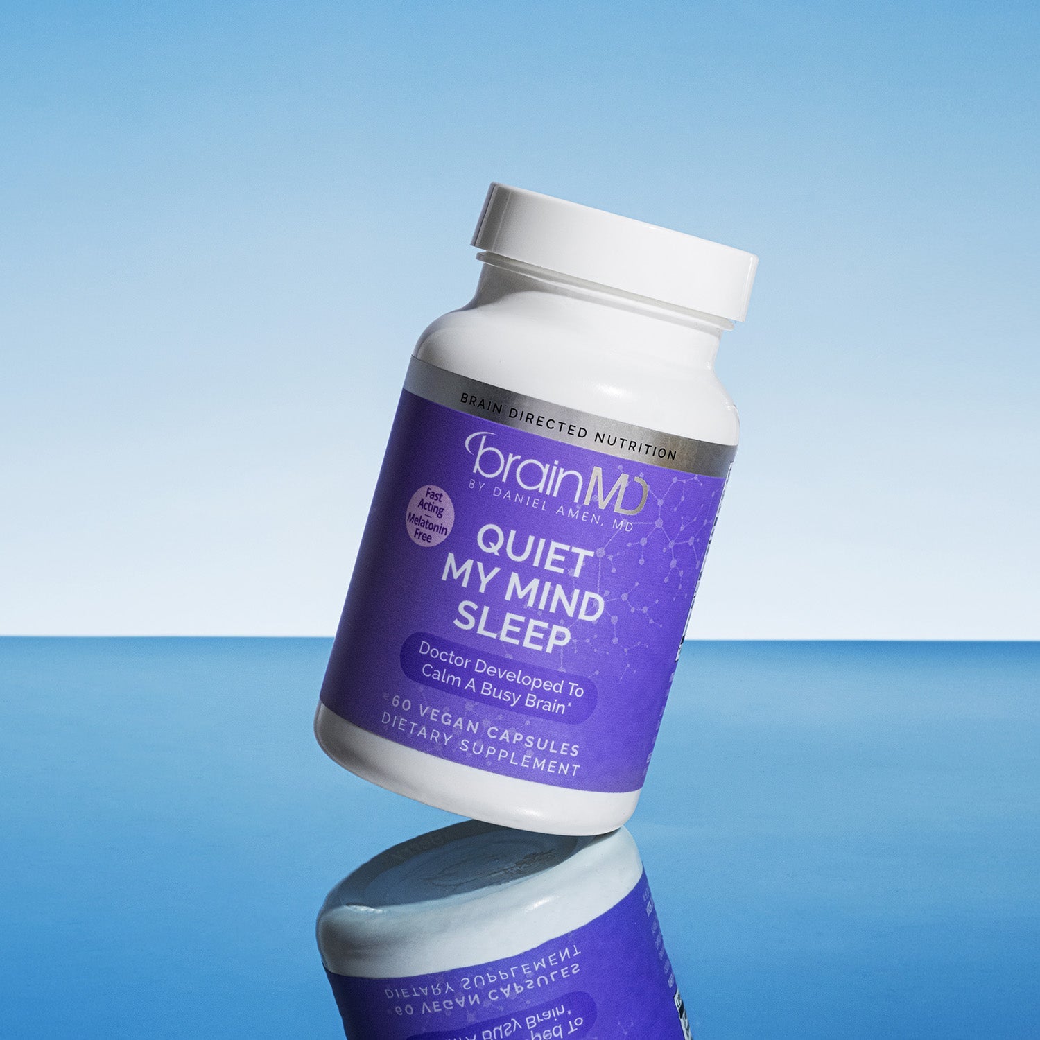BrainMD Quiet My Mind Sleep: supplement bottle sitting on top of a mirror with a blue background
