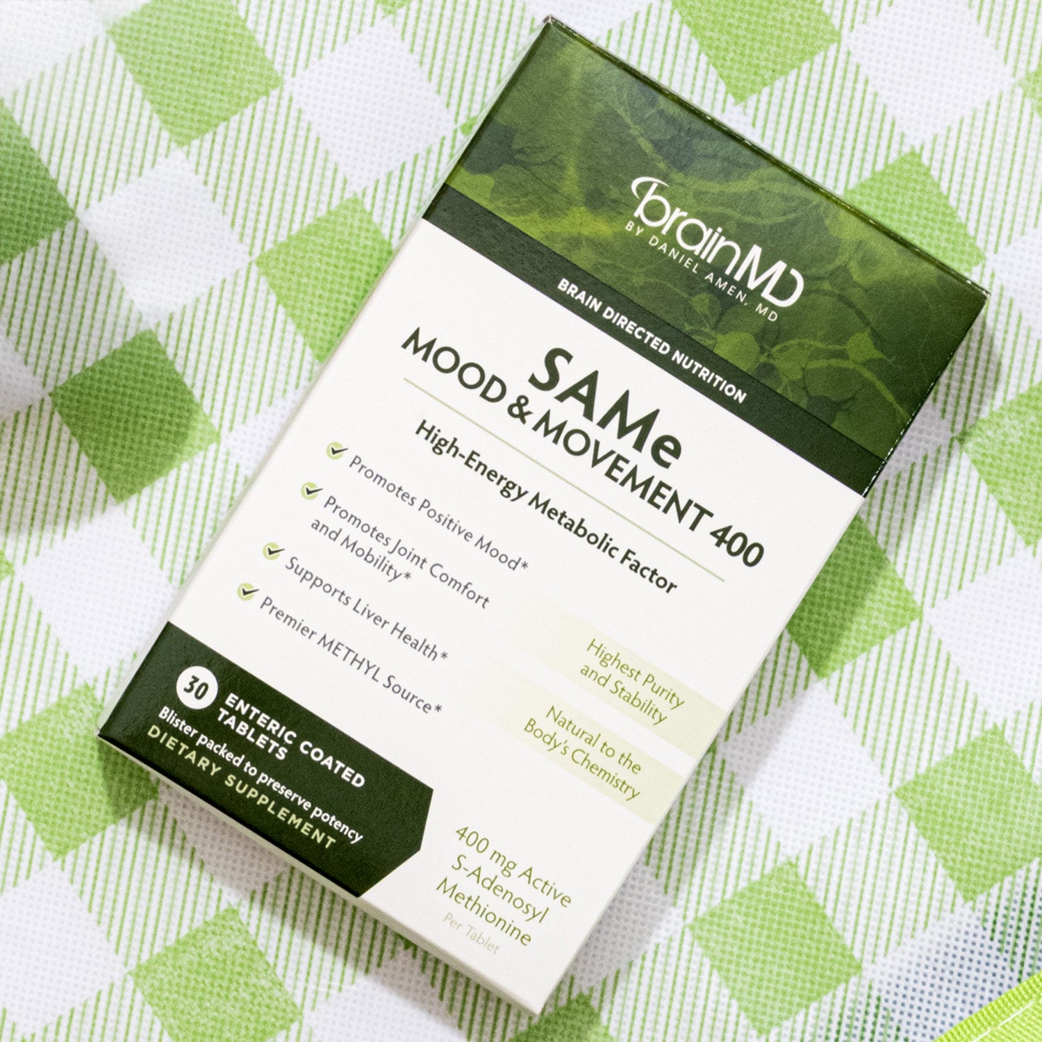 Green supplement box on a green and white checkered tablecloth.