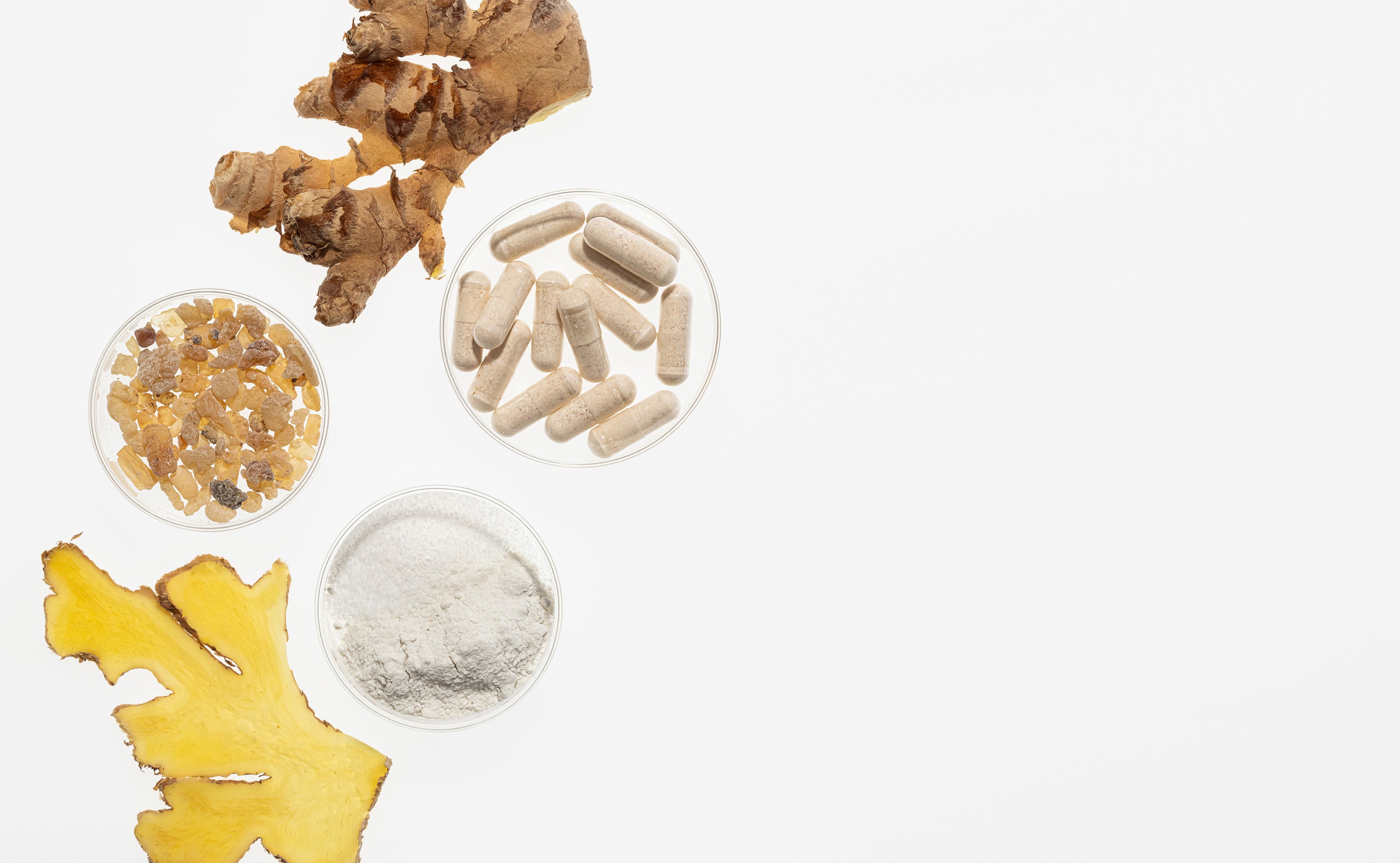 Capsules, powder, raw root and extracts against white background.