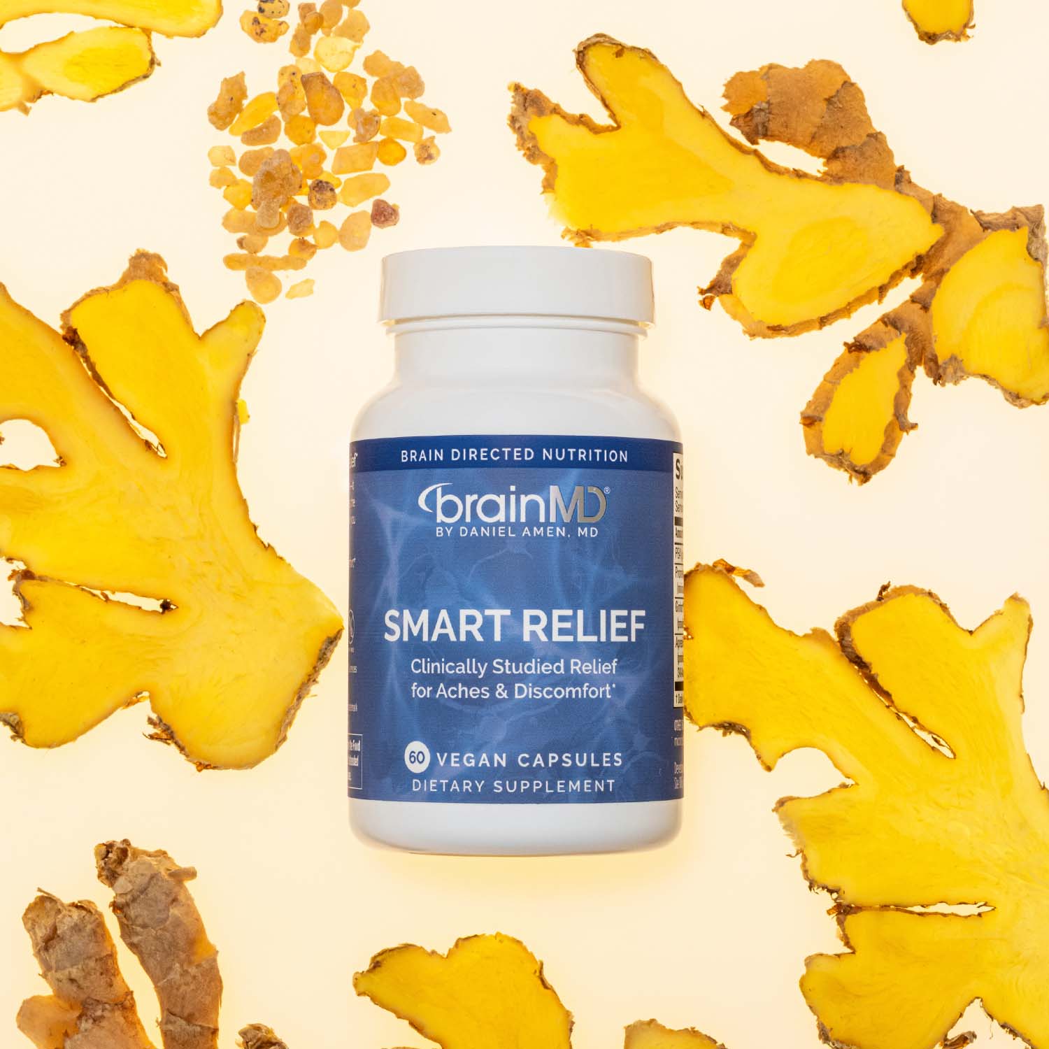 Blue supplement bottle surrounded by raw roots and extracts against an off-white background. 