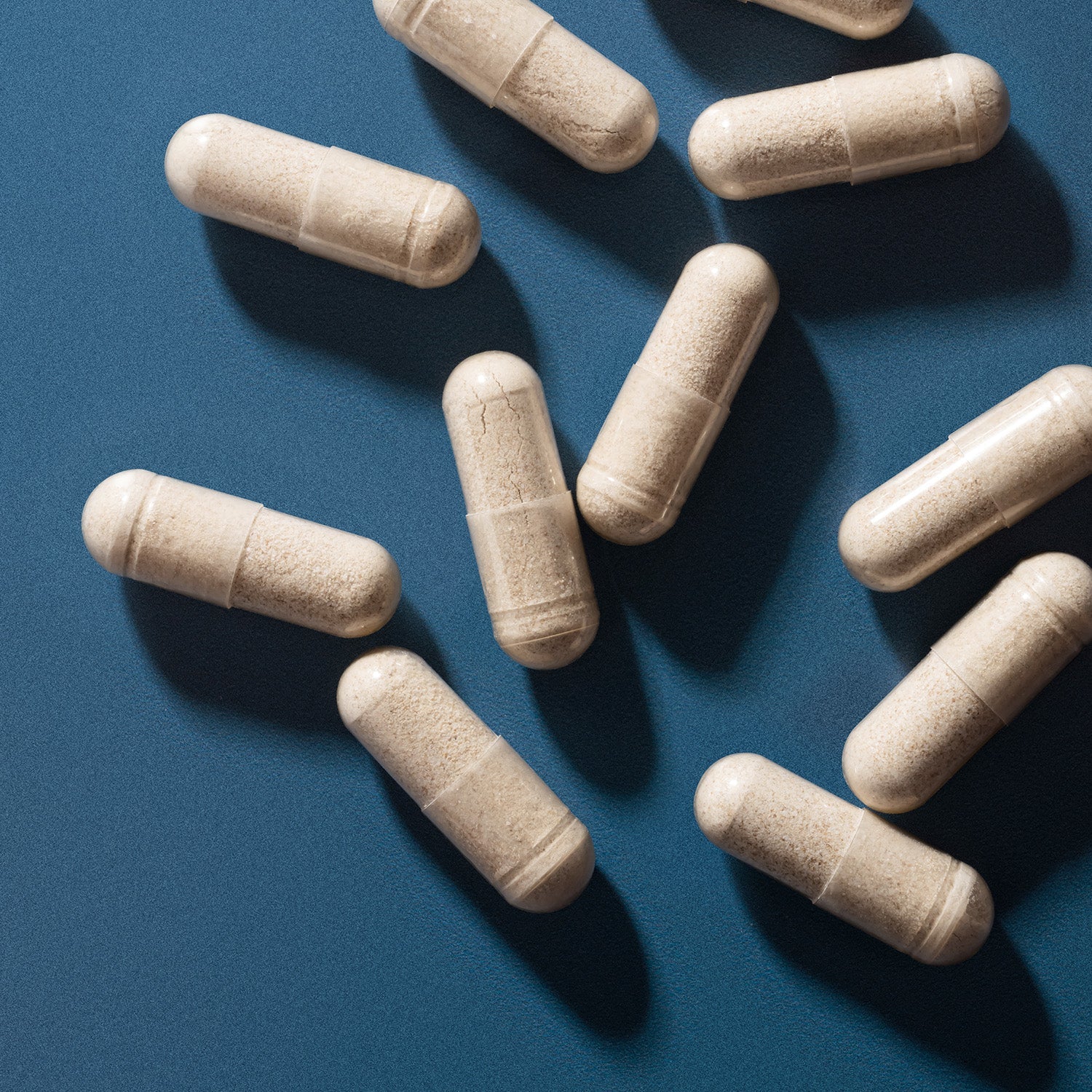 BrainMD Stress Relief Sleep: close-up image of capsules with white powder against a blue background