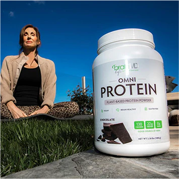 Tana Amen sitting outdoors with a container of BrainMD's Omni Protein in the foreground