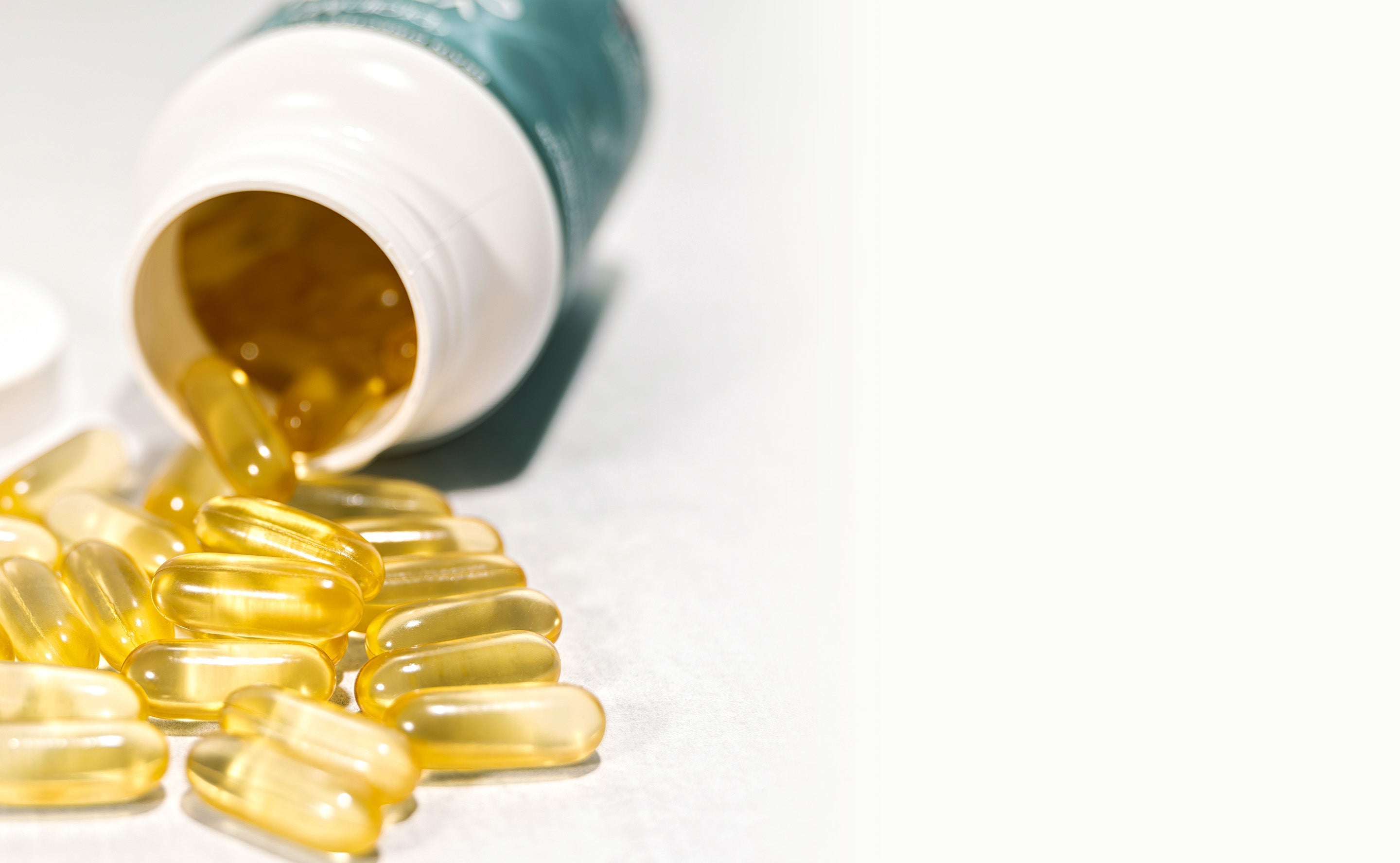 BrainMD Vegan Omega-3 Power: prone supplement bottle with golden softgels pouring out of the opening