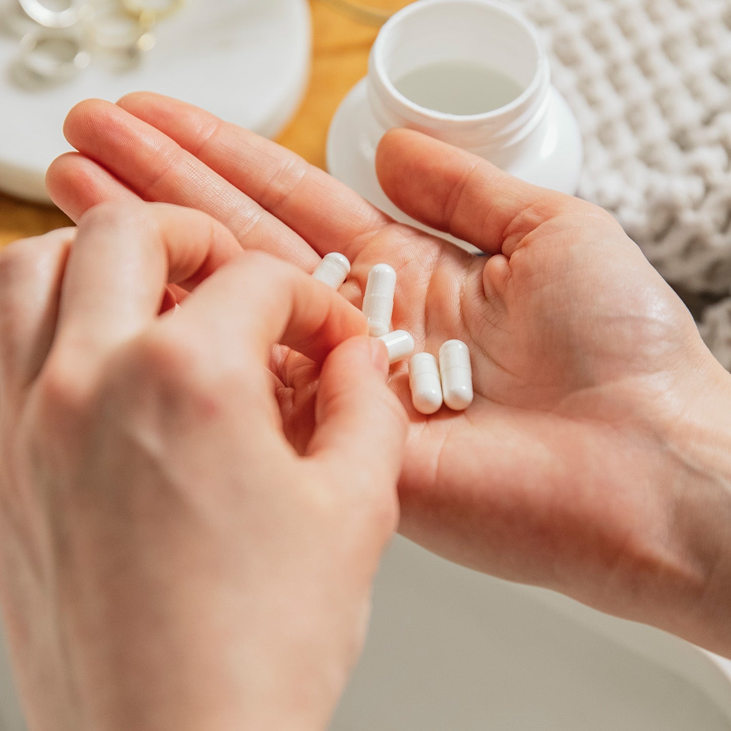 BrainMD Vitamin D3 5000: person taking a white capsule from his hand with supplement bottle in the background
