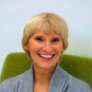 Jill Chambers smiling in front of a light blue background